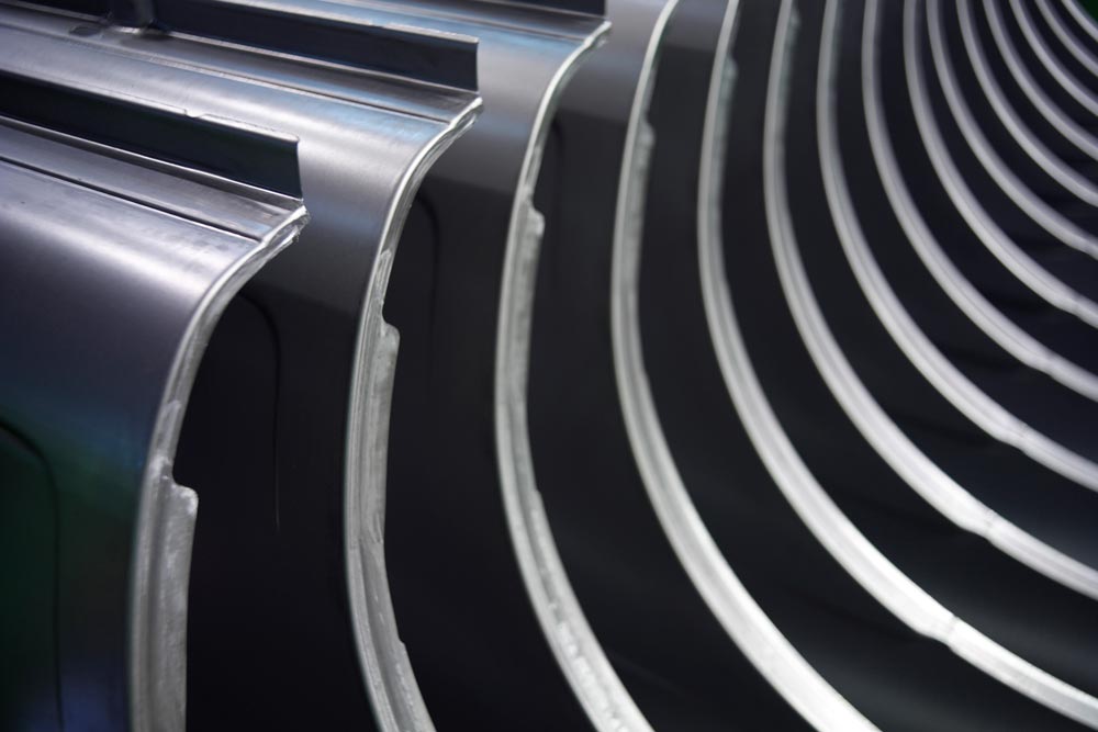 Vattenpolerade bildelar staplade i rad